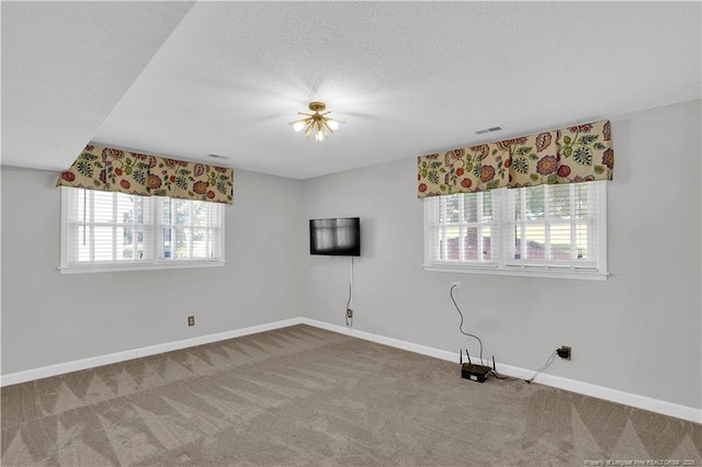 spare room featuring carpet floors, baseboards, and visible vents