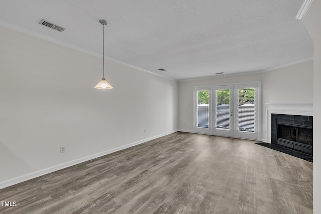 1442 Barton Place Dr, Raleigh, NC 27608 - unfurnished living room featuring visible vents, baseboards, a tiled fireplace, ornamental molding, and wood finished floors