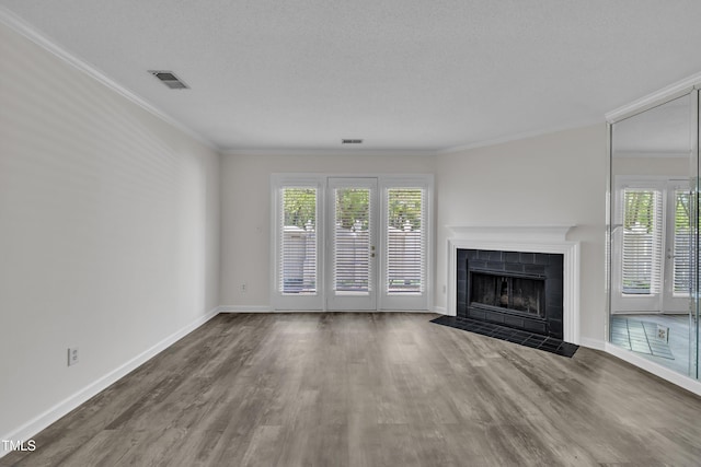 1442 Barton Place Dr, Raleigh, NC 27608 - unfurnished living room with a healthy amount of sunlight, a fireplace, visible vents, and wood finished floors