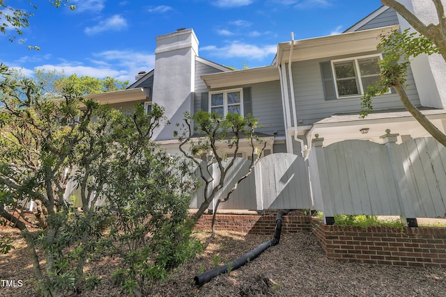 1442 Barton Place Dr, Raleigh, NC 27608 - view of side of home featuring a chimney, fence, and a gate