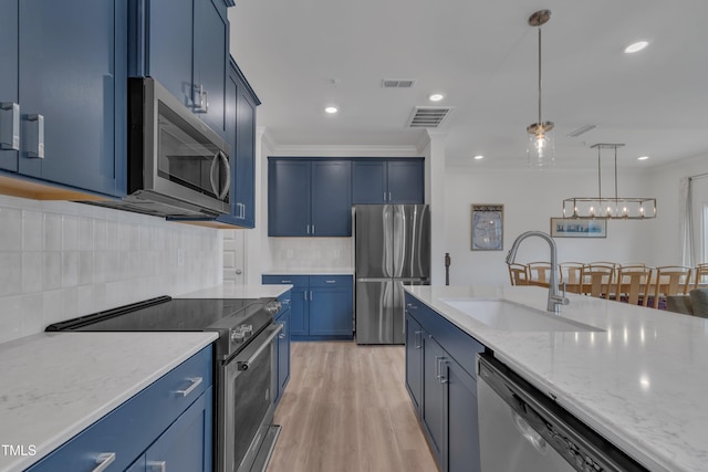kitchen with blue cabinets, a sink, visible vents, and stainless steel appliances