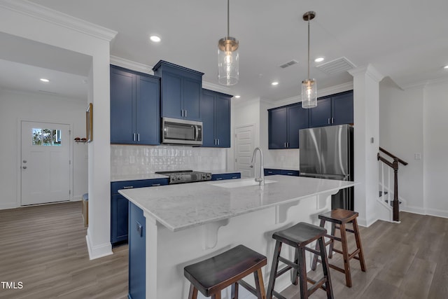 kitchen featuring blue cabinets, a sink, visible vents, and stainless steel appliances