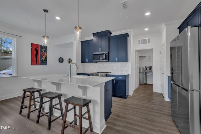 kitchen with stainless steel appliances, visible vents, a kitchen breakfast bar, and blue cabinets