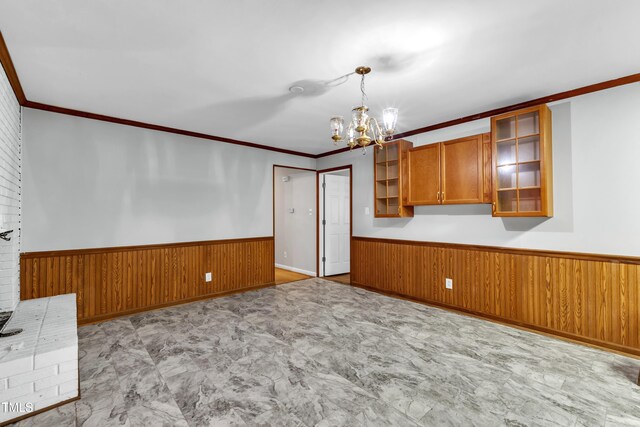 1500 Lakeside Dr, Garner, NC 27529 - kitchen with wainscoting, wood walls, a chandelier, brown cabinets, and crown molding
