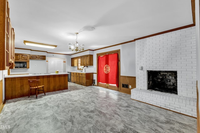 1500 Lakeside Dr, Garner, NC 27529 - kitchen featuring black microwave, brown cabinets, a peninsula, a chandelier, and crown molding