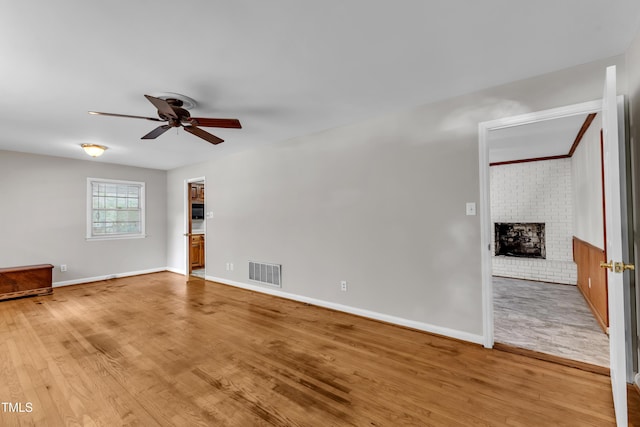 1500 Lakeside Dr, Garner, NC 27529 - unfurnished living room featuring ceiling fan, light wood-style floors, and a fireplace