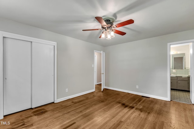 1500 Lakeside Dr, Garner, NC 27529 - unfurnished bedroom with wood finished floors, ensuite bathroom, a closet, and a ceiling fan