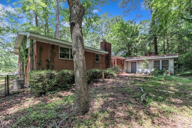 1500 Lakeside Dr, Garner, NC 27529 - back of house with brick siding and a chimney
