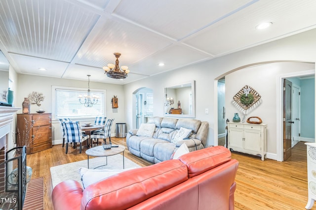 418 S 2nd St, Smithfield, NC 27577 - living room featuring baseboards, arched walkways, light wood finished floors, and a notable chandelier