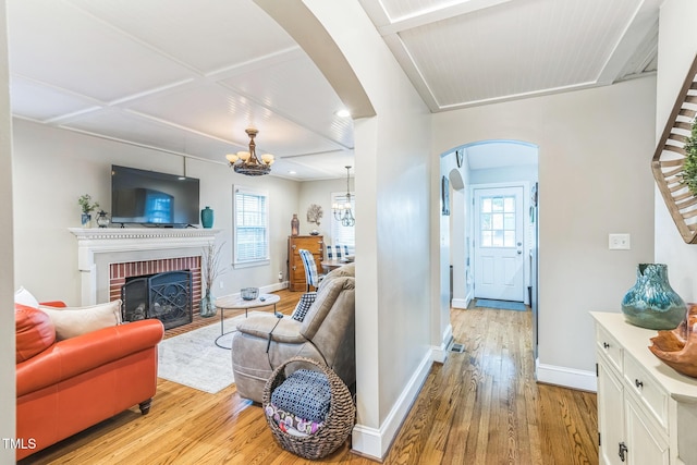 418 S 2nd St, Smithfield, NC 27577 - living room with arched walkways, an inviting chandelier, a healthy amount of sunlight, and light wood-type flooring