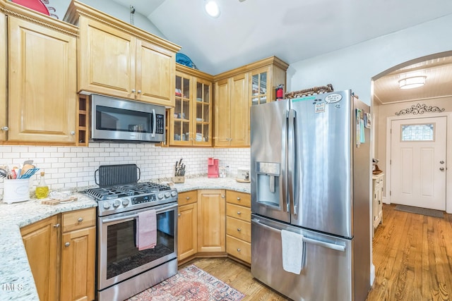 418 S 2nd St, Smithfield, NC 27577 - kitchen featuring light stone countertops, arched walkways, stainless steel appliances, light wood-type flooring, and backsplash