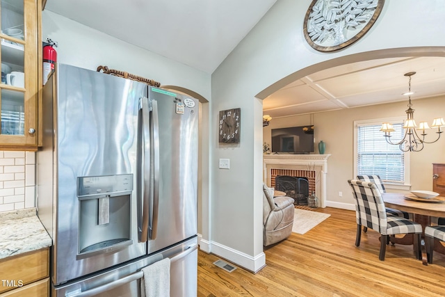 418 S 2nd St, Smithfield, NC 27577 - interior space with stainless steel fridge, light wood-style flooring, baseboards, backsplash, and glass insert cabinets