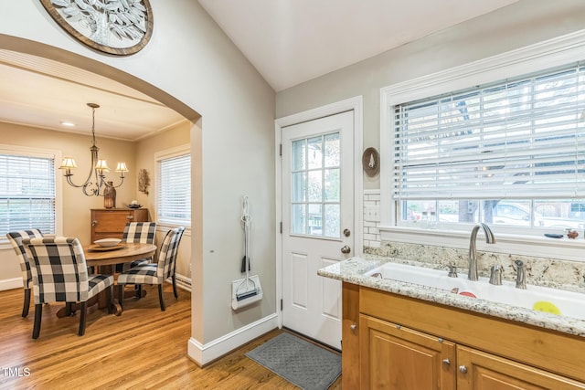 418 S 2nd St, Smithfield, NC 27577 - doorway featuring light wood-style floors, baseboards, arched walkways, a sink, and a notable chandelier