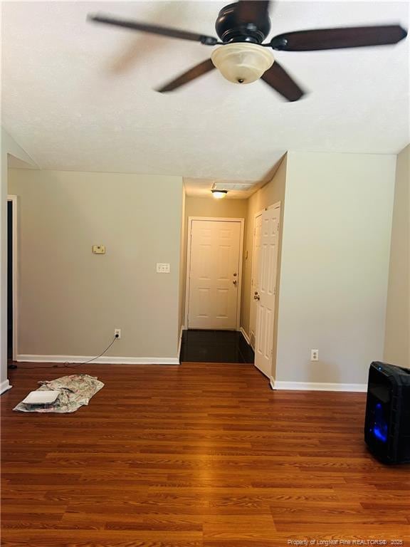 spare room with ceiling fan, wood finished floors, and baseboards