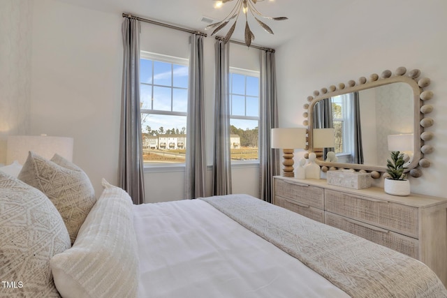 bedroom featuring visible vents and an inviting chandelier