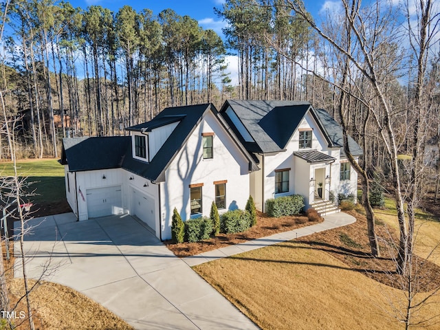 modern farmhouse featuring stucco siding, an attached garage, driveway, a front yard, and a shingled roof