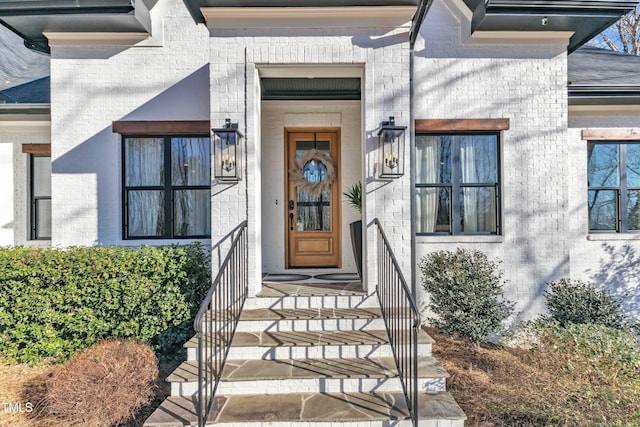 entrance to property featuring brick siding