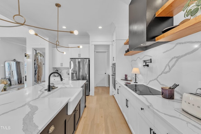 kitchen featuring white cabinets, tasteful backsplash, appliances with stainless steel finishes, a sink, and extractor fan