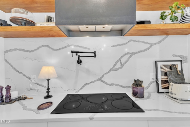 details featuring light stone countertops, exhaust hood, and black electric stovetop