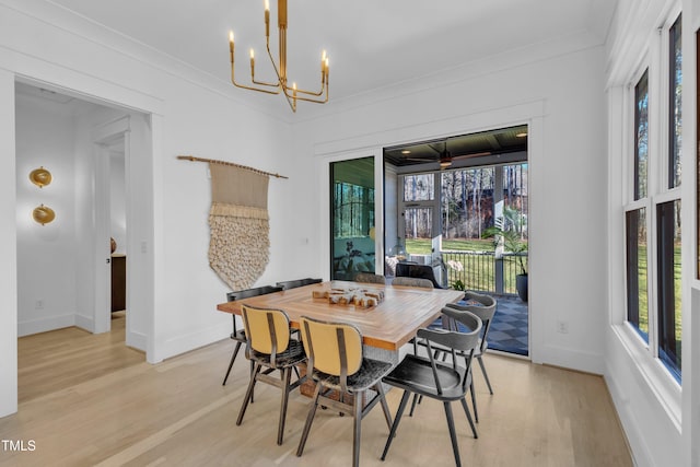 dining area featuring baseboards, a chandelier, light wood-style floors, and crown molding