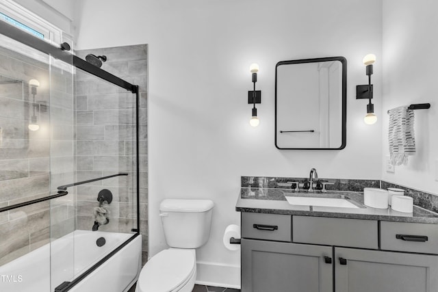 full bath with toilet, vanity, and combined bath / shower with glass door