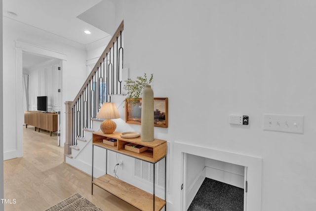 staircase featuring baseboards, wood finished floors, and recessed lighting