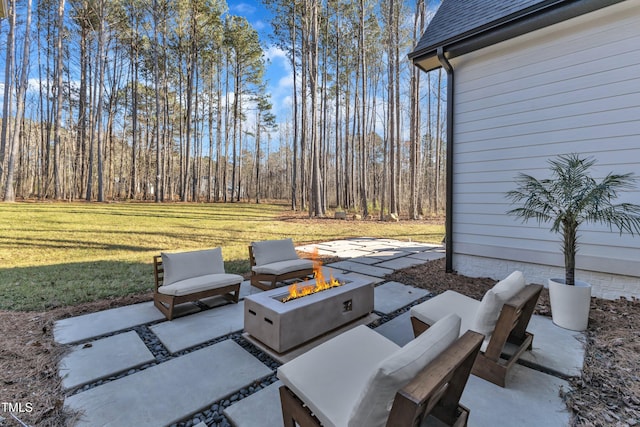 view of patio / terrace featuring an outdoor fire pit and a view of trees