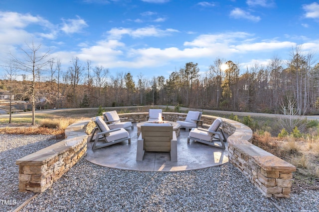 view of patio / terrace with a fire pit and a view of trees