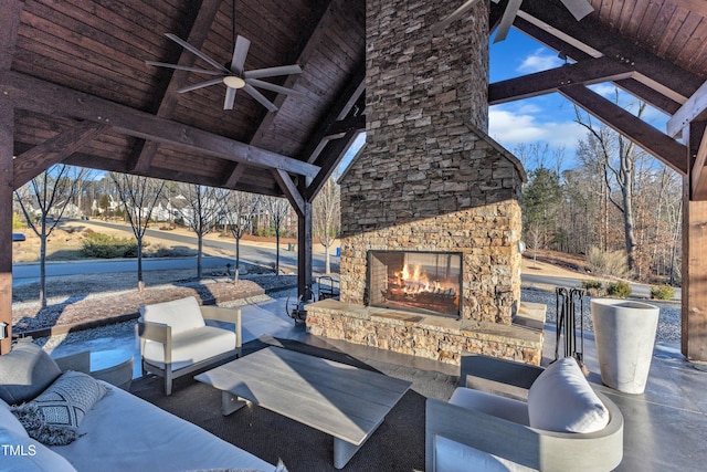 view of patio with an outdoor living space with a fireplace and ceiling fan