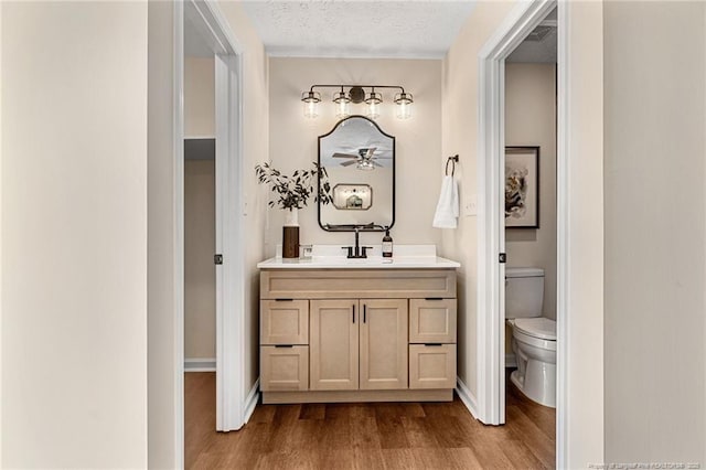 6611 Brannan Way, Fayetteville, NC 28314 - bathroom with wood finished floors, vanity, toilet, baseboards, and a textured ceiling