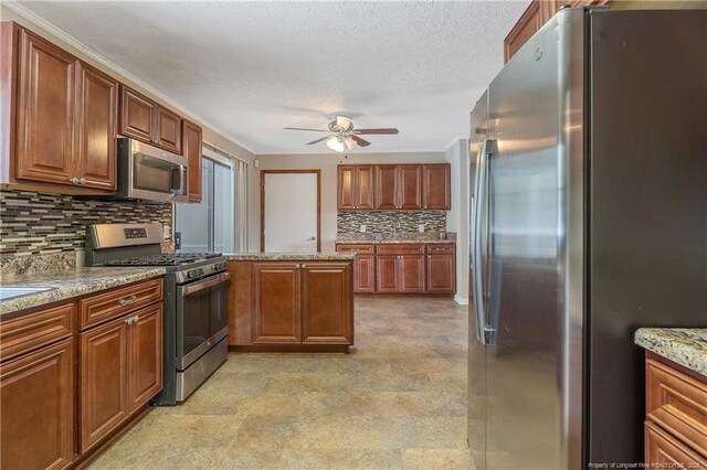 6026 Cornish St, Fayetteville, NC 28314 - kitchen featuring appliances with stainless steel finishes, ceiling fan, tasteful backsplash, brown cabinets, and a textured ceiling