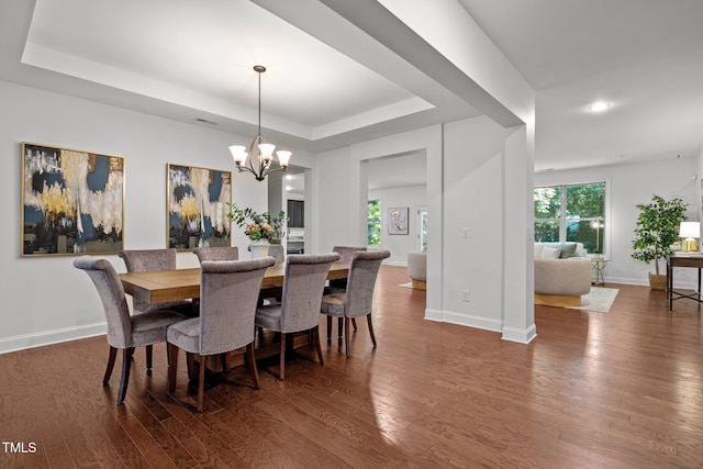 dining space featuring a chandelier, dark wood-style floors, a tray ceiling, baseboards, and recessed lighting