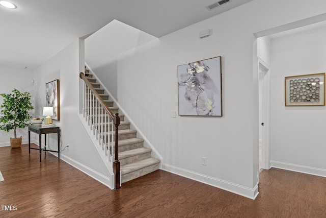 stairway with wood finished floors, baseboards, and recessed lighting