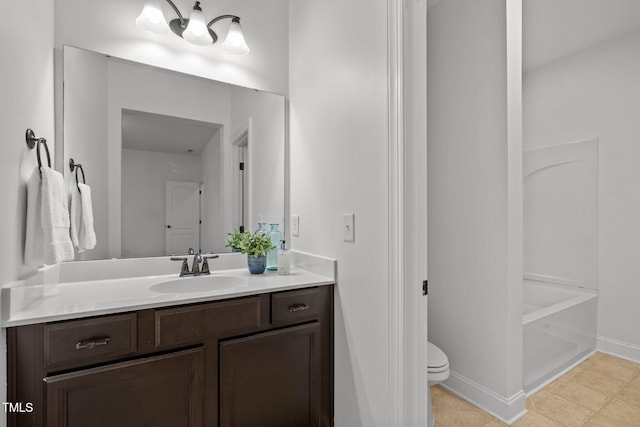bathroom featuring vanity, toilet, and baseboards
