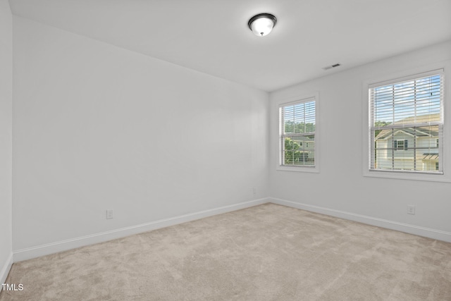 carpeted spare room featuring baseboards