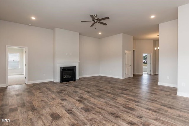unfurnished living room featuring ceiling fan, wood finished floors, a fireplace, recessed lighting, and baseboards
