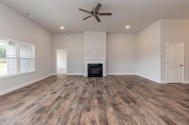 unfurnished living room with a glass covered fireplace, ceiling fan, wood finished floors, recessed lighting, and baseboards