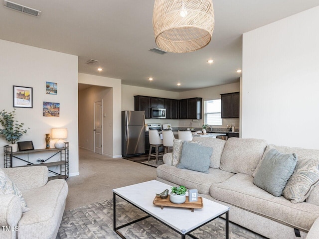 living room with light colored carpet, visible vents, and recessed lighting