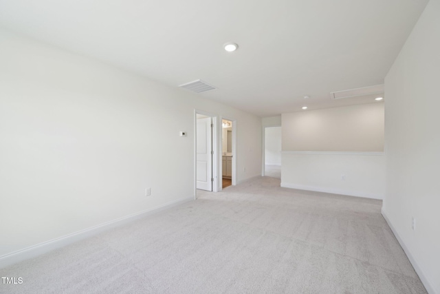 unfurnished room featuring light carpet, attic access, recessed lighting, and baseboards