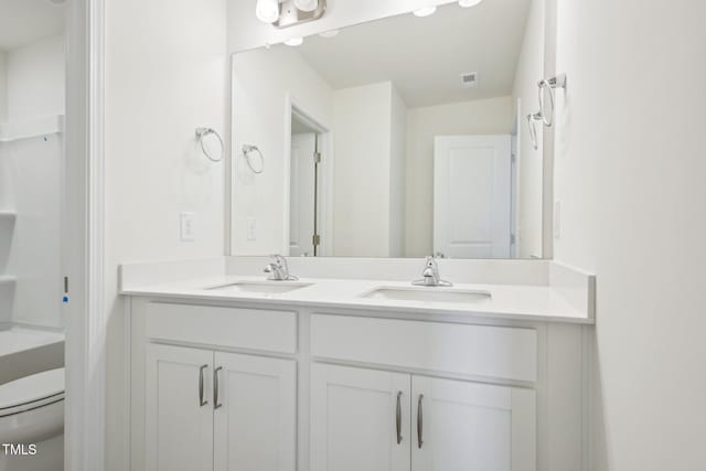 bathroom with double vanity and toilet