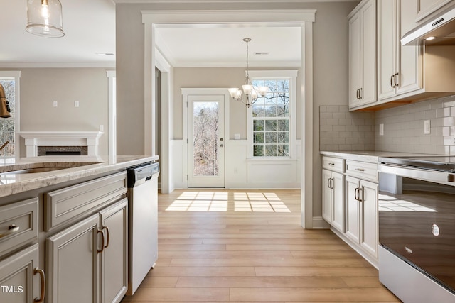 1075 Fairhaven Dr Lot 51, Mebane, NC 27302 - kitchen with under cabinet range hood, dishwasher, light wood-style flooring, a fireplace, and stainless steel range with electric stovetop