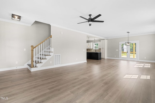 4924 Zebulon Rd, Zebulon, NC 27597 - unfurnished living room featuring a ceiling fan, light wood-style floors, crown molding, and stairway