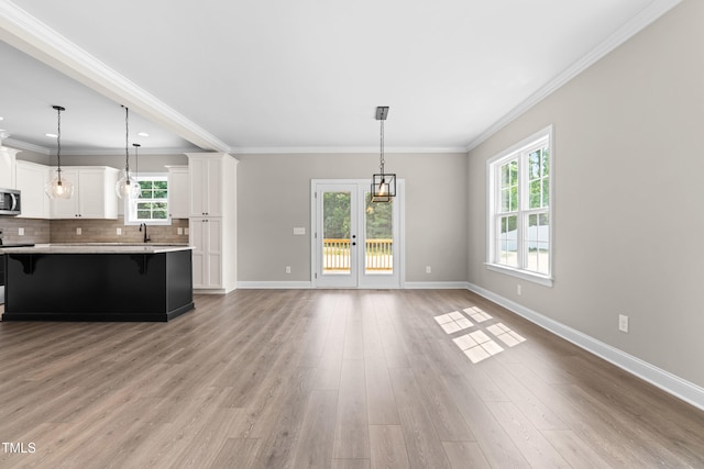 4924 Zebulon Rd, Zebulon, NC 27597 - kitchen with stainless steel microwave, a kitchen breakfast bar, light countertops, decorative backsplash, and light wood finished floors
