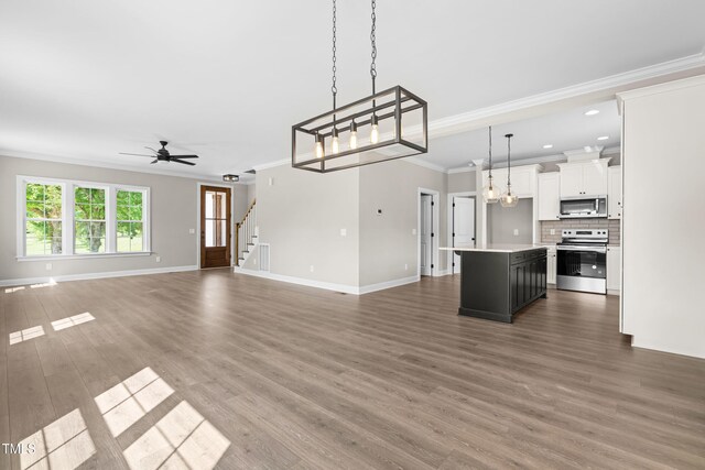 4924 Zebulon Rd, Zebulon, NC 27597 - unfurnished living room featuring ornamental molding, wood finished floors, a ceiling fan, stairs, and recessed lighting