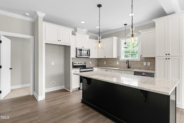 4924 Zebulon Rd, Zebulon, NC 27597 - kitchen with appliances with stainless steel finishes, backsplash, white cabinetry, crown molding, and a kitchen island
