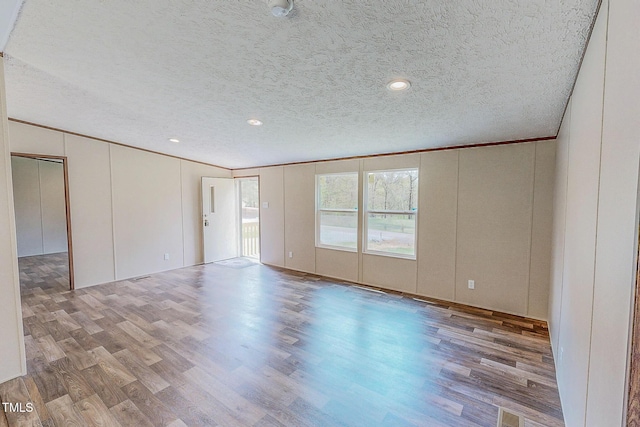 1326 Stephens Dr, Roxboro, NC 27573 - spare room with a decorative wall, a textured ceiling, wood finished floors, and ornamental molding