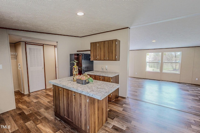1326 Stephens Dr, Roxboro, NC 27573 - kitchen featuring freestanding refrigerator, brown cabinets, dark wood-type flooring, light countertops, and a textured ceiling