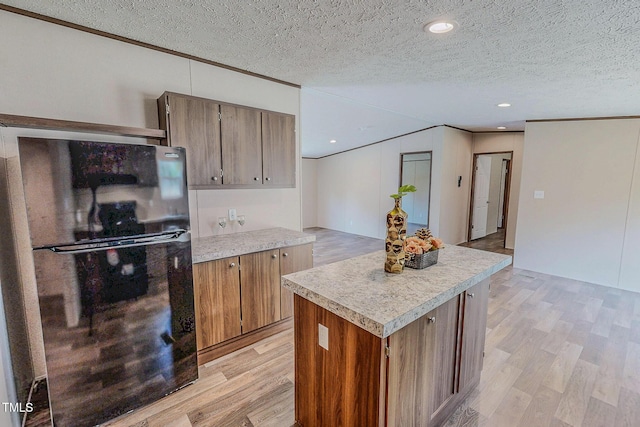 1326 Stephens Dr, Roxboro, NC 27573 - kitchen with freestanding refrigerator, light countertops, light wood-style flooring, a textured ceiling, and ornamental molding