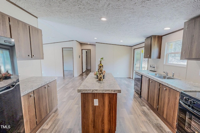 1326 Stephens Dr, Roxboro, NC 27573 - kitchen with black appliances, a sink, a kitchen island, light wood finished floors, and a textured ceiling