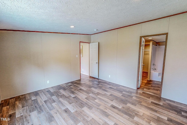 1326 Stephens Dr, Roxboro, NC 27573 - unfurnished bedroom with ornamental molding, wood finished floors, a textured ceiling, a decorative wall, and recessed lighting